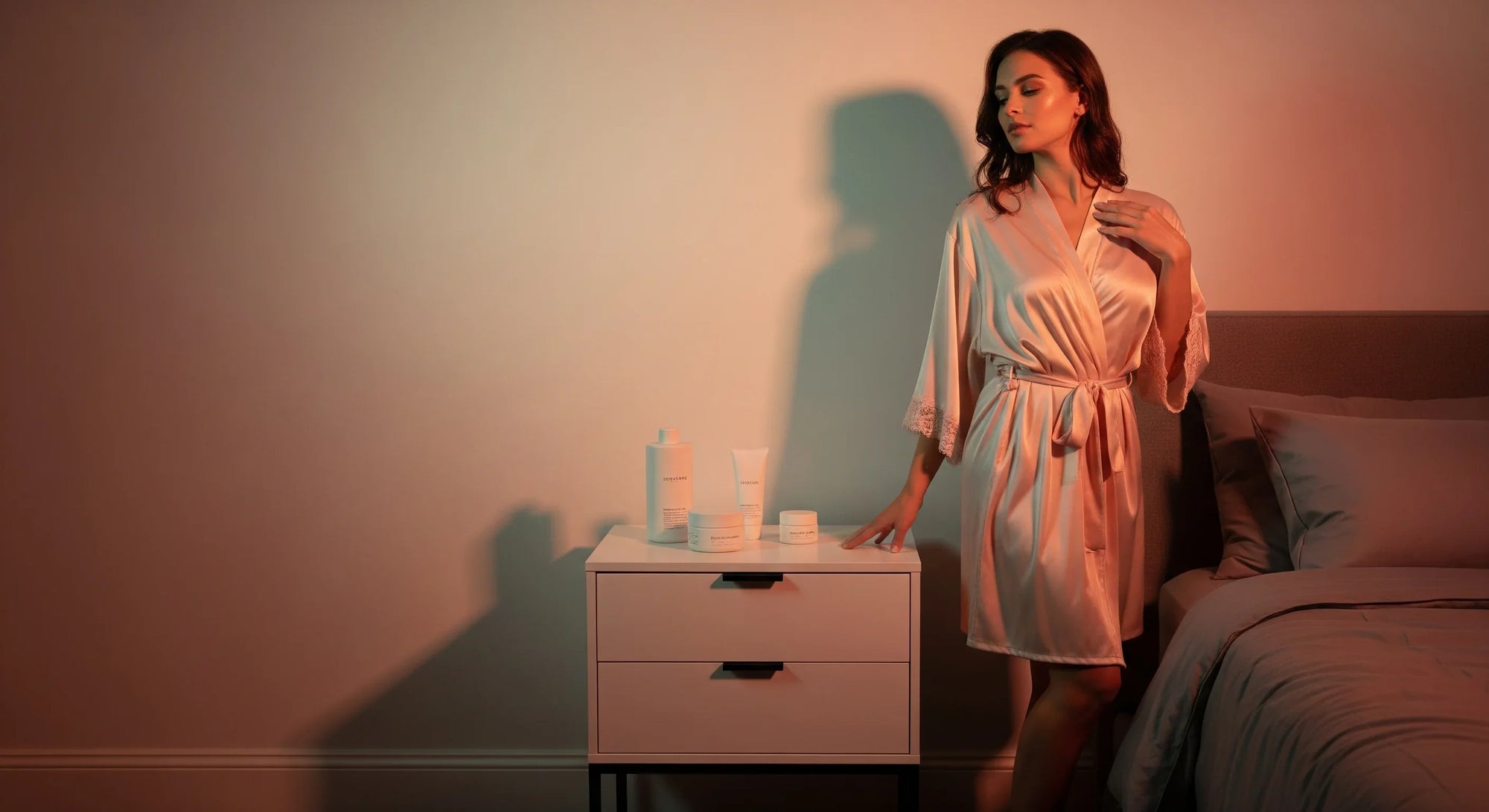 BeShapy post-op home care essentials arranged on a bed: wipes, pillow, robe, and faja with pastel decor.